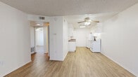 Located at 881 Soft Wind Rd in Vista, California, this single-floor residence offers a clean, functional layout designed for comfortable everyday living. Throughout the home, light wood-style flooring provides a warm, cohesive aesthetic, complemented by crisp white walls and textured ceilings.

The open living area is bright and welcoming, featuring large windows with vertical blinds that allow natural light to fill the space. A ceiling fan overhead adds comfort, and a wall-unit air conditioner ensures year-round climate control. A six-panel front door with clean trim opens directly into this inviting area.

The galley-style kitchen is efficiently designed with white cabinetry lining both sides, dark stone-look countertops, a double-basin sink, and white appliances including a range and refrigerator. A skylight above provides additional natural illumination, making the space feel open despite its compact configuration.

The bedrooms are well-proportioned and bright, each equipped with ceiling fans and windows with outdoor views. One bedroom features dual reach-in closets with shelving and hanging rods, offering generous storage capacity.

The bathroom includes a full tub-shower combination, a white vanity with storage, and wood-style flooring consistent with the rest of the home. A grab bar adds a practical accessibility feature. The overall ambiance is light, neutral, and move-in ready.