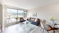 Unit 917 at 66 Main St in Yonkers, NY offers a thoughtfully designed one-bedroom, one-bathroom layout with an efficient and functional use of space. Light wood-tone flooring flows throughout, lending a clean, modern aesthetic to every room. The open-concept living and dining area is anchored by floor-to-ceiling windows that frame sweeping views of the surrounding cityscape and lush hillside beyond, filling the space with abundant natural light. The kitchen is well-appointed with light maple cabinetry, dark granite countertops, dark tile backsplash, and a full suite of stainless steel appliances including a refrigerator, range, microwave, and dishwasher. A dedicated in-unit laundry area adds everyday convenience. The hallway connects to two closets, providing generous storage. The bedroom is a serene retreat, featuring a large sliding window with the same impressive outdoor views and ample room to accommodate a full furniture arrangement. The bathroom is finished with dark slate-style floor tile, a white vanity with mirror, and a shower/tub combination. Neutral tones throughout create a cohesive, contemporary ambiance ideal for comfortable urban living in downtown Yonkers.