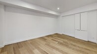 Located on Avenue des Pins Ouest in Montréal's vibrant Milton-Parc neighbourhood, this efficiently designed unit offers a clean, contemporary aesthetic throughout its single floor. Light wood plank flooring runs continuously through the space, complementing crisp white walls and recessed lighting that create a bright, open atmosphere.

The entrance leads into the main living area, where large windows flood the space with natural light and frame views of the surrounding Montréal streetscape and historic brick architecture. A dedicated balcony extends the living area outdoors, offering a pleasant urban outlook.

The kitchen is thoughtfully appointed with high-gloss white cabinetry, light stone countertops, a stainless steel refrigerator, an induction cooktop, and an integrated sink — all arranged in a compact, functional layout. A baseboard heating system runs beneath the windows, ensuring year-round comfort.

The bathroom features full-height beige tile walls, a soaking bathtub with overhead shower, a white vanity with undermount sink, and tile flooring, presenting a clean and cohesive finish. A dedicated closet provides practical storage, while the additional rooms offer flexible use as a bedroom or living space. The overall ambiance is modern, minimal, and move-in ready.