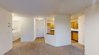Located in St. Louis Park, MN, this 2-bedroom, 2-bathroom residence offers a practical and comfortable single-floor layout. The open living room features soft carpeting, neutral walls, a textured ceiling, and a sliding glass door that opens to a private balcony with outdoor views — allowing natural light to fill the space. The kitchen is positioned adjacent to the living area and is defined by warm honey-toned cabinetry, dark countertops, a tile floor, a full appliance suite including a stainless steel microwave and range, and a pass-through breakfast bar that connects it to the main living space. The spacious primary bedroom features a bay-style multi-panel window that brings in generous natural light and is finished with plush carpeting. The second bedroom also features carpet flooring and a window with outdoor views. Both bathrooms include a full tub and shower combination with white tile surround and tile flooring. The unit includes two closets with wire shelving systems for ample storage. A dedicated laundry room houses a full-sized Whirlpool washer and dryer. The overall aesthetic is clean and functional, with consistent neutral finishes throughout.