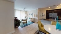 This single-floor residence is thoughtfully designed with an open, flowing layout that connects the main living spaces seamlessly. The living room serves as the heart of the home, featuring crown molding, a ceiling fan, and large sliding glass doors that frame serene waterfront views and invite abundant natural light. Light-toned tile flooring extends throughout the common areas, complementing the warm, neutral wall palette.

The kitchen is a standout feature, outfitted with rich dark cabinetry, granite countertops, a mosaic tile backsplash, and a full suite of stainless steel appliances. Crown molding continues into this space, adding a refined detail overhead.

A dedicated dining area sits adjacent to the kitchen, while the open-concept arrangement allows for comfortable interaction between the cooking and living spaces.

The two bedrooms each offer a distinct character. One features soft blue-gray walls and plush carpeting, creating a calm, restful atmosphere. The second bedroom carries warm tones and decorative wall accents. Both bathrooms echo the kitchen's design sensibility with dark cabinetry, granite countertops, and full tub-shower combinations with tile surrounds, providing a cohesive, polished finish throughout the residence.