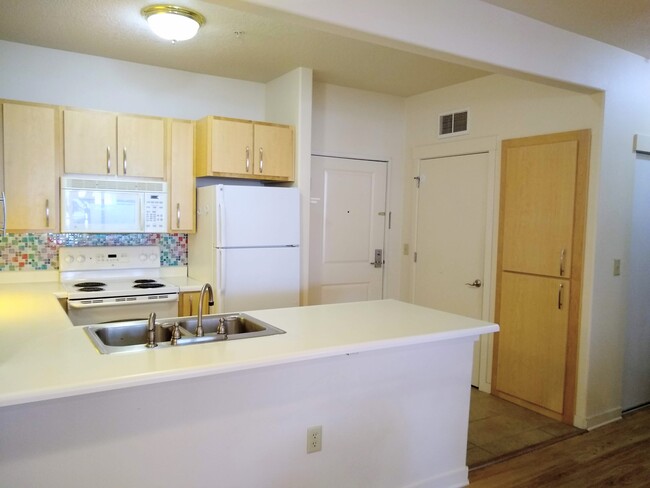 Kitchen, front door, laundry room door (right), and pantry storage (far right) - 400 NE 100th Ave