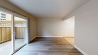 This single-floor residence offers a clean, functional layout designed for comfortable everyday living. The living area is spacious and filled with natural light, featuring warm wood-style laminate flooring and neutral beige walls that create a bright, welcoming atmosphere. A full-width sliding glass door opens directly to a private patio, enclosed by a wood fence and lattice paneling, providing a seamless indoor-outdoor connection.

The galley-style kitchen is efficiently arranged with white cabinetry lining both sides, offering ample upper and lower storage. Warm brown laminate countertops, a stainless steel sink, a four-burner electric range, and a full-size refrigerator complete the space, all set on light ceramic tile flooring. An adjacent dining nook with matching tile flooring and a ceiling fan provides a dedicated space for meals.

The bedroom is generously proportioned with the same wood-style flooring, a large window that brings in natural light, and access to a spacious walk-in closet equipped with a full-width shelf and hanging rod for organized storage.

The bathroom features a full soaking tub with a shower, accented by floor-to-ceiling stone-look tile surround and chrome fixtures, paired with light tile flooring. A wall-mounted HVAC unit and a floor heater ensure year-round comfort throughout the home.