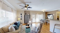 This single-story residence in Spring, Texas offers a comfortable and well-designed layout with two bedrooms and two full bathrooms. The open-concept living and dining area serves as the heart of the home, featuring warm hardwood-style flooring, crown molding, and a ceiling fan. Large windows dressed with sheer white curtains and wood blinds allow generous natural light to fill the space, creating a bright and welcoming atmosphere. A set of glass doors provides additional access to the outdoors.

The kitchen is a functional galley-style layout equipped with rich medium-toned cabinetry, granite-style countertops, a mosaic tile backsplash, and a full suite of stainless steel appliances including a range, microwave, refrigerator, and dishwasher. The kitchen opens conveniently toward the dining area.

Both bedrooms feature plush carpeting, ceiling fans, and windows with natural light. The primary bedroom includes a walk-in closet and direct access to its en-suite bathroom. A built-in desk with a granite-style surface offers a dedicated workspace nook. The bathrooms are clean and bright, with tiled tub-shower combinations. Overall, the space offers a cohesive, comfortable living environment.