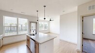 Located at 2220 Berryhill Road in Charlotte, NC, this thoughtfully designed 2-bedroom, 2-bathroom residence offers a modern aesthetic across a single, well-organized floor. The open-concept living, dining, and kitchen area forms the heart of the home, anchored by a large kitchen island with quartz countertops, a matte black faucet, and stylish pendant lighting. Light wood cabinetry, stainless steel appliances — including a refrigerator, range, and over-the-range microwave — white subway tile backsplash, and large windows flooding the space with natural light complete the kitchen. Light hardwood-style flooring flows through the main living areas, while ceiling fans provide comfort throughout. Both bedrooms feature plush carpeting, generous natural light, and ceiling fans. The primary bedroom connects to an en-suite bathroom with a double-sink vanity, quartz countertops, and matte black fixtures. The second bathroom offers a full tub-shower combo with white subway tile and coordinating black hardware. Four closets — including a spacious walk-in — provide ample storage. A dedicated laundry area and utility room add everyday convenience. A private balcony rounds out this well-appointed residence.