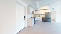 Located in Hallandale Beach, FL, this contemporary 3-bedroom, 2-bathroom residence at 215 Park offers a clean, modern aesthetic throughout its single-floor layout. Light wood-style flooring flows consistently across the living areas and bedrooms, complementing the crisp white walls and creating a bright, airy atmosphere.

The open-concept kitchen is thoughtfully designed with flat-front white cabinetry extending to the ceiling, a striking marble-look backsplash, gray quartz countertops, and stainless steel appliances including a range, over-the-range microwave, dishwasher, and refrigerator. The entry opens directly into this well-appointed kitchen and living area, giving the space a welcoming, functional flow.

Each bedroom is well-proportioned and filled with natural light courtesy of large windows that frame lush, tree-lined outdoor views. Ceiling fans are featured in the bedrooms, adding comfort alongside the abundant natural ventilation. A private balcony extends the living experience outdoors.

Both bathrooms are finished with elegant marble-look porcelain tile and feature floating wood-toned vanities with white countertops and backlit mirrors. The tub-shower combinations are lined with full-height marble-patterned tile and framed with sleek sliding glass doors, delivering a polished, spa-like feel throughout.