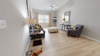 This 910 square foot apartment in Raleigh, NC offers a thoughtfully designed living space with two bedrooms and two bathrooms. The single-story layout maximizes efficiency, featuring an open-concept living, dining, and kitchen area that promotes a sense of spaciousness.

The primary bedroom, measuring 150 square feet, provides a comfortable retreat with ample space for a queen-sized bed and additional furnishings. Both bedrooms showcase light wood flooring and are adorned with stylish decor, creating inviting spaces for rest and relaxation.

The living room boasts a contemporary aesthetic with a grey sofa, accent pillows, and a patterned ottoman. Large windows allow natural light to flood the space, while a ceiling fan ensures comfort. The dining area features a modern glass table with upholstered chairs, perfect for intimate meals or entertaining guests.

The kitchen, though compact, is well-equipped with white appliances and ample cabinet space. Its galley-style layout maximizes functionality, with countertops on both sides and a patterned rug adding a touch of warmth to the space.

Both bathrooms are designed with practicality in mind, featuring clean lines and neutral color schemes. One bathroom includes a shower/tub combination with a decorative curtain, while the other offers a vanity with ample storage.

Throughout the apartment, light wood flooring and neutral wall colors create a bright, airy atmosphere. Thoughtful touches such as decorative mirrors, artwork, and plants add character to the space. This apartment offers a perfect blend of style and functionality for modern urban living.