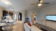 This thoughtfully designed two-bedroom, two-bathroom residence in Spring, TX delivers a comfortable and modern living experience across a single floor. The open-concept living area features wood-look flooring, crown molding, a ceiling fan, and textured accent walls, with an elegant arched passageway connecting the living space to the rest of the unit. The kitchen is well-appointed with dark espresso cabinetry, granite countertops, a grey subway tile backsplash, stainless steel appliances, and ample storage. A charming dining nook with a bay window arrangement floods the space with natural light. Both bedrooms are generously sized, each with ceiling fans, large windows, and soothing neutral tones accented by a bold teal feature wall. The primary bedroom includes a walk-in closet and direct access to its private bathroom. The primary bath offers a granite-topped vanity with dark cabinetry and a glass-enclosed walk-in shower, while the second bathroom features a matching vanity and a full soaking tub with subway tile surround. Wood-look flooring flows throughout the main areas, complementing the cohesive and polished aesthetic of the entire unit.