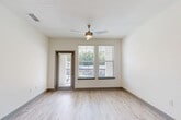 Located at 1050 Beckoning Blvd in Charlotte, NC, this well-appointed one-bedroom, one-bathroom residence offers a thoughtfully designed open-concept layout with modern finishes throughout. Light-toned hardwood-style flooring flows seamlessly through the main living areas, complementing the bright, neutral color palette.

The kitchen is a standout feature, showcasing gray shaker-style cabinetry, granite countertops, a classic white subway tile backsplash, and a full suite of stainless steel appliances including a refrigerator, range, microwave, and dishwasher. A central island with pendant lighting above provides additional prep space and connects effortlessly to the living area, which enjoys views of the balcony through large windows and a glass door.

The bedroom is generously sized, carpeted for comfort, and filled with natural light from a bank of windows overlooking the outdoors. A ceiling fan adds to the room's functionality, and a dedicated closet offers ample storage.

The bathroom is cleanly finished with tile flooring, a granite-topped vanity with gray cabinetry, and a full tub-shower combination with tile surround. Additional conveniences include an in-unit laundry area and a private balcony, making this a practical and attractive residence in Charlotte.