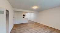 Located at 5700 Ackerfield Ave in Long Beach, California, this single-floor unit offers a thoughtfully updated interior with a clean, move-in-ready aesthetic throughout. The open living and dining area is finished with light-toned wood-look flooring and neutral white walls, creating a bright and airy atmosphere. A textured ceiling and flush-mount lighting complement the space, while a pass-through opening connects the living area to the kitchen, enhancing the sense of openness. Natural light filters in through large windows dressed with vertical blinds, adding to the welcoming ambiance.

The kitchen is well-appointed with grey shaker-style cabinetry, black hardware, and crisp white quartz countertops. Stainless steel appliances — including a gas range, over-the-range microwave, and French door refrigerator — are paired with track lighting overhead and durable wood-look flooring, making it both functional and stylish.

The bedrooms are generously sized, each featuring the same light flooring, vertical blinds for privacy, and ceiling fans for added comfort. The bathroom includes a clean tiled tub and shower surround with a simple, minimalist design. A wall heater is also present in the living space, providing practical climate control. This unit presents a refreshed, low-maintenance living environment in a convenient Long Beach location.