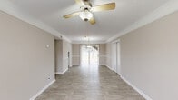 Located at 750 Chateau Ln in Riverdale, GA, this single-story, one-bedroom, one-bathroom home offers a practical and well-organized layout across a comfortable footprint. Light wood-look flooring flows throughout the main living areas, complemented by neutral warm-beige walls and white trim that create a clean, cohesive aesthetic.

The dining room is a bright and inviting space, featuring large sliding glass doors with vertical blinds that flood the room with natural light and provide direct access to the outdoors. A pendant light fixture and crown molding add a refined touch. The kitchen is efficiently designed with white cabinetry, white countertops, a double stainless steel sink beneath a window, and a black electric range — offering ample storage and a practical workspace.

The bedroom is generously proportioned, finished with plush wall-to-wall carpeting, a ceiling fan with light fixture, and dual sliding-door closets that provide abundant storage. A window allows natural light to brighten the space. The bathroom is neatly appointed with wood-look flooring, a tub-shower combo with tile surround, a toilet, and a vanity with a light countertop, all framed by a wainscoting-style chair rail detail. A hallway connects the rooms, completing this cohesive and functional home.