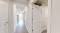 Located at 3710 S Angeline St in Seattle's Seward Park neighborhood, this two-bedroom, one-bathroom unit offers a clean, modern aesthetic throughout. Light wood-look flooring flows seamlessly through the main living areas and bedrooms, complemented by crisp white walls and recessed lighting that keep the space feeling bright and airy.

The open living area is a highlight, featuring large sliding glass doors that lead to a private balcony with expansive views of the surrounding Seattle landscape. A wall-mounted mini-split unit ensures year-round comfort. The kitchen is well-equipped with white shaker cabinetry extending to the ceiling, a classic white subway tile backsplash, light quartz countertops, and a full suite of stainless steel appliances including a gas range, microwave, dishwasher, and refrigerator.

A long, light-filled hallway connects the living areas to the two bedrooms, both featuring wood-look flooring and clean white finishes. The primary bedroom includes a dedicated closet with built-in shelving. The full bathroom is finished with large-format gray tile flooring, a white vanity, and a tub and shower combination enclosed by a sliding glass door with white subway tile surround. A dedicated closet provides additional storage to round out this thoughtfully designed home.