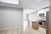 Located on the 29th floor of a contemporary high-rise at 20 George Street in downtown Hamilton, this well-appointed one-bedroom, one-bathroom unit offers a thoughtfully designed open-concept layout with light wood-look flooring throughout. The combined kitchen and living area forms the heart of the unit, featuring a modern kitchen equipped with stainless steel appliances — including a refrigerator, built-in oven, cooktop, and microwave — complemented by two-tone cabinetry in white gloss and warm wood-grain finishes, a subway tile backsplash, and a central island with a sleek countertop ideal for dining or meal prep. The spacious bedroom is bathed in natural light through large floor-to-ceiling windows and a sliding glass door that opens to a balcony, offering expansive views of Hamilton Harbour and the surrounding cityscape. A built-in wood-tone wardrobe provides generous storage. The four-piece bathroom features a soaker tub and shower combination, a wood-accented vanity, and consistent light flooring. In-suite laundry with a stacked washer and dryer adds everyday convenience. Neutral tones and modern finishes create a clean, contemporary ambiance throughout.