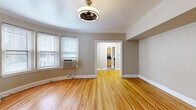 Located at 1050 N Sherman St in Denver's vibrant Capitol Hill neighborhood, this well-appointed 1-bedroom, 1-bathroom unit showcases a thoughtful layout across a single floor. Warm hardwood flooring runs continuously throughout the living areas, hallways, and bedroom, lending a cohesive and inviting feel to the entire space.

The living areas are highlighted by a distinctive curved wall — a standout architectural feature that adds character and elegance. Crown molding accents the ceilings, while a ceiling fan with a classic fixture provides both style and function. Natural light filters in through multiple windows fitted with blinds, brightening the neutral, taupe-toned walls.

The kitchen features light maple cabinetry with ample storage, dark granite-style countertops, stainless steel appliances, and a bold black-and-white checkerboard tile floor that adds a retro charm. Two closets provide generous storage options throughout the unit.

The bedroom is comfortably sized, with a dedicated closet and a window overlooking the surroundings. The bathroom retains classic character with penny-tile flooring, subway-style wall tile, and a pedestal sink. A dark wood door frames the bathroom entry, adding a rich contrasting detail. The hallways connect the rooms efficiently, completing a functional and stylish floor plan.