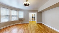 Located at 1050 N Sherman St in Denver's vibrant Capitol Hill neighborhood, this well-appointed 1-bedroom, 1-bathroom unit showcases a thoughtful layout across a single floor. Warm hardwood flooring runs continuously throughout the living areas, hallways, and bedroom, lending a cohesive and inviting feel to the entire space.

The living areas are highlighted by a distinctive curved wall — a standout architectural feature that adds character and elegance. Crown molding accents the ceilings, while a ceiling fan with a classic fixture provides both style and function. Natural light filters in through multiple windows fitted with blinds, brightening the neutral, taupe-toned walls.

The kitchen features light maple cabinetry with ample storage, dark granite-style countertops, stainless steel appliances, and a bold black-and-white checkerboard tile floor that adds a retro charm. Two closets provide generous storage options throughout the unit.

The bedroom is comfortably sized, with a dedicated closet and a window overlooking the surroundings. The bathroom retains classic character with penny-tile flooring, subway-style wall tile, and a pedestal sink. A dark wood door frames the bathroom entry, adding a rich contrasting detail. The hallways connect the rooms efficiently, completing a functional and stylish floor plan.