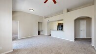 Located at 10502 Fountain Lake Dr in Stafford, TX, this single-story, 3-bedroom, 3-bathroom residence offers a well-designed layout across a comfortable footprint. The open-concept living area features vaulted ceilings and a ceiling fan, creating an airy atmosphere filled with natural light from large windows that overlook greenery outside. Plush carpet flows throughout the living and bedroom areas, while wood-look flooring anchors the kitchen and bathrooms.

The kitchen is appointed with rich dark-espresso cabinetry, granite-style countertops, a peninsula with a sink, and black appliances including a refrigerator, range, and built-in microwave. The space opens seamlessly to the living area, making it ideal for everyday functionality.

The primary bedroom is generously sized and includes a ceiling fan, natural light, and access to a private bathroom featuring a granite-top vanity with dark cabinetry, wood-look flooring, and a tiled tub-shower combo. A spacious walk-in closet with wire shelving accompanies the primary suite. The additional bedrooms are well-proportioned, each with carpet and ceiling fans. The bathrooms share a consistent design with tiled tub-shower combinations and wood-look flooring. A dedicated laundry room houses a full-size washer and dryer, adding everyday convenience to this thoughtfully arranged home.
