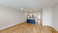This contemporary residence at 100 Rosemoor Drive, McDonough, GA, offers 1380 square feet of living space across two floors. The ground floor spans 610 square feet, while the upper level provides 770 square feet of space. The home boasts three bedrooms, including a primary bedroom of 140 square feet, and three full bathrooms.

The kitchen is a standout feature, showcasing white cabinetry with gold hardware, stainless steel appliances, and a striking blue island with a quartz countertop. Two gold pendant lights hang above the island, adding a touch of elegance. A subway tile backsplash in light blue complements the overall color scheme.

Throughout the home, warm-toned hardwood floors create a cohesive and inviting atmosphere. The living areas are bright and airy, with large windows allowing ample natural light. Window treatments include white horizontal blinds for privacy and light control.

The bedrooms are spacious and neutral, featuring ceiling fans for comfort. The bathrooms are modern and sleek, with white vanities, quartz countertops, and large mirrors. The home also includes two closets for additional storage.

A single-car garage with a concrete floor and an automatic door opener provides secure parking. The property's exterior combines brick and siding, creating an appealing facade. This well-designed home offers a perfect blend of style and functionality in a desirable location.