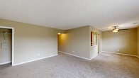 Located at 9115 Knights Bridge Blvd in Indianapolis, Indiana, this single-floor, 2-bedroom, 2-bathroom home offers a comfortable and functional layout throughout. The open-concept living and dining area is carpeted and bathed in natural light, with warm neutral-toned walls, a ceiling fan, and a sliding glass door that opens to an outdoor space with pleasant exterior views. A second window adds to the bright, airy feel of this central gathering area.

The kitchen is well-appointed with warm wood cabinetry, light countertops, stainless steel appliances including a refrigerator, range, and microwave, plus a dishwasher and a dedicated pantry with louvered bifold doors. Light wood-style flooring runs throughout the kitchen, which connects conveniently to the dining area via a pass-through opening.

The primary bedroom offers a comfortable footprint with plush carpeting, neutral walls, a closet with sliding doors, and direct access to a private en suite bathroom featuring a walk-in shower with glass doors. The second bedroom is similarly carpeted and features its own closet. A second full bathroom includes a tub/shower combination, wood vanity, and light flooring. Additional conveniences include three closets, a dedicated laundry area, and a hallway connecting all rooms efficiently.