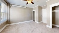 Located at 326 Juniper St in San Diego, CA, this single-floor unit offers a thoughtfully designed layout centered around a generously sized bedroom. The room is finished with soft, neutral-toned walls in warm beige and complemented by clean white crown molding and baseboards that lend a polished, classic character to the space.

Plush wall-to-wall carpeting runs throughout, adding warmth underfoot and contributing to a quiet, comfortable atmosphere. A ceiling fan with a built-in light fixture is centrally positioned, providing both air circulation and ambient lighting. Crown molding lines the ceiling, adding an elegant architectural detail.

A large, multi-pane window dressed with horizontal blinds floods the room with natural light while offering views of the surrounding neighborhood. A built-in bench or ledge beneath the window provides a charming architectural accent. The entry door is solid white and features a deadbolt lock, contributing to a sense of security.

The space includes a dedicated closet outfitted with a hanging rod and shelf, offering practical storage. An additional doorway leads to a secondary area, providing flexible use of the layout. The overall ambiance is clean, bright, and move-in ready, making this San Diego unit a functional and comfortable urban retreat.