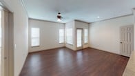 This single-floor residence offers a thoughtfully designed layout that balances comfort and functionality throughout. The open-concept living area serves as the heart of the home, showcasing rich hardwood-style flooring, crown molding, and a ceiling fan overhead. Multiple windows dressed with white blinds invite an abundance of natural light, creating a bright and airy atmosphere, while a glass-paned exterior door provides direct outdoor access.

The kitchen is efficiently arranged with dark espresso cabinetry, granite-style countertops, and a full suite of stainless steel appliances, including a refrigerator, gas range, built-in microwave, and dishwasher. Crown molding detail continues into the kitchen, adding a refined architectural touch.

Adjacent to the kitchen, a dedicated laundry closet houses a full-size washer and dryer, offering added convenience. The bedroom features plush wall-to-wall carpeting and a clean, neutral palette, providing a quiet retreat. The bathroom is appointed with dark wood cabinetry, a single-basin vanity with stone-look countertops, and hardwood-style flooring that extends into a spacious walk-in closet with built-in shelving and hanging rods. The overall aesthetic throughout the space is cohesive and modern, with neutral tones and quality finishes.