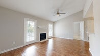Located at 53 Northtown Dr in Jackson, Mississippi, this single-floor, one-bedroom, one-bathroom residence offers a well-organized layout across a compact yet efficient footprint. The living room serves as the centerpiece of the home, showcasing warm hardwood flooring, vaulted ceilings, and a ceiling fan with light fixture. A fireplace with a clean white mantel anchors one wall, flanked by windows dressed with white shutters that allow abundant natural light to fill the space. The neutral gray-toned walls create a bright, welcoming ambiance throughout. The kitchen is thoughtfully designed with white shaker-style cabinetry, light countertops, a tile backsplash, and stainless steel appliances including a French door refrigerator and range. Hardwood flooring continues into the kitchen, maintaining a cohesive aesthetic. The generously sized primary bedroom features plush carpeting, a ceiling fan, and a window with shutters that brings in soft natural light. The bathroom includes a full soaking tub-shower combination with clean white fixtures. A dedicated entryway with a paneled door and thermostat panel completes this functional and comfortable single-level home.