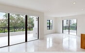 This contemporary 3-bedroom, 2-bathroom apartment in Coral Gables offers 1450 square feet of thoughtfully designed living space. The open floor plan maximizes the sense of spaciousness, with a seamless flow between the living areas and kitchen. The kitchen is a standout feature, boasting sleek white upper cabinets contrasted with warm wood lower cabinets, and a large central island perfect for casual dining or entertaining.

Natural light floods the interior through floor-to-ceiling windows, which also provide access to a generous balcony overlooking the cityscape. The bathrooms are elegantly appointed with modern fixtures, including glass-enclosed showers and floating vanities. The bedrooms, including a 210 square foot primary suite, offer ample space and comfort.

Throughout the apartment, neutral tones and high-quality finishes create a sophisticated ambiance. Recessed lighting and carefully chosen fixtures add to the modern aesthetic. The property's location at 701 Valencia Ave places residents in the heart of Coral Gables, known for its Mediterranean-style architecture and vibrant community. This apartment represents an ideal blend of style, comfort, and urban living.