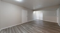 Located at 3523 Fawn Valley Dr in Dallas, Texas, this single-floor, three-bedroom, two-bathroom home offers a clean, functional layout designed for comfortable everyday living. Light-toned luxury vinyl plank flooring runs consistently throughout the space, lending a cohesive and modern aesthetic to every room.

The living room provides a comfortable gathering area, featuring neutral walls, vertical blinds that allow natural light to filter in, and a door leading to an exterior access point. The galley-style kitchen is well-appointed with white shaker cabinetry extending to the ceiling, light stone-finish countertops, a stainless sink, and black appliances including an electric range and refrigerator. Track lighting above adds bright, even illumination.

Each of the three bedrooms offers a practical layout with neutral warm-gray walls, built-in closets with bifold doors, and ceiling-mounted flush lighting. The primary bedroom includes a dedicated closet and connects conveniently to the rest of the home via a central hallway.

Both bathrooms are finished consistently, each featuring a single-sink vanity with a stone-look countertop, a full tub-shower combination with white tile surround, and wood-look flooring. The overall interior palette of whites, grays, and light wood tones creates a clean, move-in-ready environment throughout.