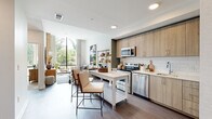 Located at 7970 Maitland St in McLean, Virginia, this thoughtfully designed single-floor residence showcases a seamless open-concept layout that connects the kitchen, dining, and living areas into one cohesive space. The contemporary kitchen is outfitted with light wood cabinetry, stainless steel appliances, a classic white subway tile backsplash, and clean white countertops, complemented by a freestanding island that doubles as a casual dining surface. Wide-plank hardwood-style flooring runs throughout the main living areas, lending warmth and continuity.

The living room is a standout feature, boasting soaring ceilings and dramatic floor-to-ceiling windows that frame lush greenery and flood the space with abundant natural light. An elegant tufted sofa, marble-topped coffee table, and warm wood accent pieces complete the refined aesthetic.

The bedroom continues the floor-to-ceiling window theme, offering sweeping views of mature trees and an adjoining outdoor terrace. A soft color palette, plush carpeting, and an upholstered headboard create a calm, restful retreat.

The bathroom is well-appointed with a wide vanity, light wood cabinetry, white countertops, large-format tile, and a tub-shower combination, rounding out this polished and well-considered residence.