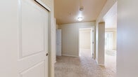 Located in the Harbour Landing community of Regina, Saskatchewan, this one-bedroom, one-bathroom unit offers a practical and efficient layout designed for comfortable everyday living. The kitchen is a standout feature, finished with rich dark-toned cabinetry, light countertops, and durable tile flooring. It is equipped with a full suite of black appliances, including a refrigerator, electric range, and over-the-range microwave, along with a peninsula that provides additional workspace and a natural transition into the living area. Soft, neutral-toned carpet flows throughout the living space, hallway, and bedroom, creating a warm and cohesive feel. The bedroom is a well-sized retreat featuring a sliding closet door and clean, cream-toned walls, offering a calm and understated atmosphere. The hallway connects all areas of the unit efficiently and provides access to an in-suite washer and dryer, adding significant day-to-day convenience. The bathroom includes a full-sized soaker tub and shower combination with clean white surround, a toilet, and chrome fixtures. Throughout the unit, the neutral color palette, flush-mount lighting, and consistent finishes contribute to a clean, move-in-ready aesthetic.