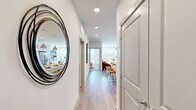 Located at 17501 Dallas Parkway in Dallas, TX, this well-appointed one-bedroom, one-bathroom residence offers a thoughtfully designed single-floor layout with a clean, contemporary aesthetic throughout. A bright entryway hallway with recessed lighting and light wood-style flooring leads into the open-concept kitchen and living area. The kitchen is a standout feature, boasting white shaker cabinetry, a subway tile backsplash, stainless steel appliances including a French door refrigerator, and a spacious waterfall island with bar seating illuminated by industrial-style pendant lights. The adjoining living room is bathed in natural light from large floor-to-ceiling windows and features a ceiling fan overhead, creating an airy, comfortable atmosphere. The bedroom continues the light, neutral palette with plush carpeting, a ceiling fan, and expansive windows that bring in generous outdoor views. A dedicated closet with full-width hanging storage connects directly to the bedroom. The bathroom is finished in crisp white tones with wood-style flooring, a wide vanity with under-mount sink, backlit mirror, and a tiled tub-shower combination. Recessed lighting throughout the unit ensures a bright and welcoming ambiance in every room.