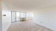 Located at 3701 Conshohocken Ave in Philadelphia, PA, this two-bedroom, one-bathroom residence offers a well-organized single-floor layout with a practical and straightforward design. The living room is a generously sized, light-filled space featuring large floor-to-ceiling windows dressed with vertical blinds, a sliding glass door, and a wall-mounted HVAC unit. The abundance of natural light and elevated outdoor views lend the living area an open, airy feel, complemented by neutral carpeting throughout.

The kitchen is equipped with white cabinetry offering ample storage, dark countertops, a gas range, refrigerator, and a dishwasher. A distinctive patterned tile floor adds character to this functional cooking space.

Both bedrooms are carpeted and bright, with the primary bedroom being notably spacious. Each room features large windows with vertical blinds that frame outdoor views, along with wall-mounted heating units. Two closets provide dedicated storage throughout the unit.

The bathroom is finished with white tile flooring and includes a shower-tub combination, toilet, and vanity, with a safety grab bar installed. The overall design of the residence is clean and neutral, offering a functional canvas well-suited to personalization.