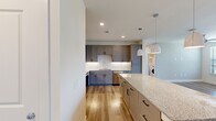 This thoughtfully designed single-floor residence features 4 bedrooms and 3 bathrooms, offering a functional and modern living environment. The open-concept kitchen and living area serves as the heart of the home, showcasing gray shaker-style cabinetry with black hardware, granite countertops, a decorative geometric tile backsplash, stainless steel appliances, and pendant lighting over a large central island. Light wood-look flooring runs throughout the main living areas, adding warmth and continuity to the space.

The four bedrooms are carpeted and filled with natural light through large windows with exterior views. The primary bedroom is a comfortable size and includes a dedicated walk-in closet with built-in shelving and hanging rods for ample storage. The three bathrooms are finished with granite vanity tops, white cabinetry, and large-format tile surround tub-shower combinations, reflecting a clean and cohesive design aesthetic.

A dedicated laundry room with side-by-side Whirlpool washer and dryer units provides added convenience, complete with open shelving above for storage. The overall ambiance of this residence is bright, modern, and move-in ready, with consistent finishes and a practical layout that maximizes every square foot of the space.