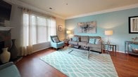 Located at 389 Stone Creek Pt in Charlottesville, Virginia, this single-floor residence offers a thoughtfully designed layout with a cohesive color palette and quality finishes throughout. The living room is a welcoming focal point, featuring rich hardwood flooring, crown molding, large windows that invite natural light, and a striking stone-surround fireplace. Teal accent walls and coordinating decor lend the space a calm, contemporary feel.

The open dining area connects seamlessly to the kitchen via decorative columns, enhancing the sense of flow. The kitchen is well-equipped with warm maple cabinetry, dark granite-style countertops, tile flooring, and a full suite of stainless steel GE appliances, including a range with overhead microwave.

The bedrooms are carpeted for comfort and feature soothing teal-toned accent walls, generous closet space, and windows dressed with sheer curtains for soft, diffused light. The primary bedroom is particularly spacious, with room for a sitting area and easy access to an adjoining bath.

Two full bathrooms are finished with tile flooring, maple vanity cabinetry, and tub-shower combinations. One bathroom features teal walls while the other has a bold charcoal finish, each providing a distinct yet cohesive design identity within the home.