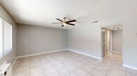 Located at 8395 Magnolia Ave in Riverside, CA, this single-floor, 2-bedroom, 2-bathroom unit offers a well-organized layout with tile flooring running throughout. The open living room greets you at the entry, featuring large windows that bring in natural light, a textured ceiling, and a wall-mounted air conditioning unit. The kitchen is a functional highlight, equipped with granite-style countertops, gray cabinetry, a stainless steel dishwasher, a gas range, a double-basin sink, and a wood-accented peninsula that separates the kitchen from the living area. Both bathrooms are clean and simply appointed, each featuring a tub-shower combo with white surrounds and tile flooring. The primary bedroom offers a comfortable footprint with two mirrored sliding closet doors, a ceiling fan, a window for natural light, and a wall-mounted AC unit. The second bedroom is similarly laid out with tile flooring, a ceiling fan, and direct hallway access. A connecting hallway links all rooms efficiently, providing a logical flow throughout the unit. The consistent gray-toned walls and light tile flooring create a neutral, cohesive aesthetic that carries from room to room, making the space feel clean and move-in ready.