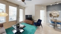 This single-floor residence showcases a cohesive modern design carried consistently throughout each room. The kitchen is a standout feature, equipped with stainless steel appliances including a refrigerator, dishwasher, microwave, and range. Two-tone cabinetry pairs dark wood lower cabinets with crisp white upper cabinets, all complemented by granite countertops and light wood-look flooring that extends underfoot.

The living area benefits from multiple windows that invite natural light and provide outdoor views, with direct access through a side door. Light wood flooring continues here, contributing to an open, airy feel. Adjacent to the living space, the dining area features a distinct two-tone painted accent wall and connects visually to the kitchen.

The bedrooms are carpeted for comfort, each offering ceiling fans, generous natural light from large windows, and a calm, neutral palette. One bedroom provides an ensuite bath, while additional bathrooms feature granite-topped dark wood vanities, tile flooring, and a tub-shower combination with white tile surround.

The bathrooms maintain a consistent design language with the kitchen, using matching granite countertops and dark cabinetry, creating a unified aesthetic throughout the entire residence.