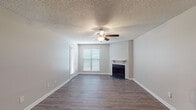 This single-story residence in Memphis, Tennessee, offers a well-organized layout across one bedroom and one bathroom. The living area serves as the focal point of the unit, featuring wood-style flooring in a warm gray-brown tone, neutral gray walls, and a textured ceiling. A ceiling fan with integrated lighting provides both airflow and illumination, while a fireplace with a clean white surround anchors one wall, adding a functional and aesthetic element to the space. Multiple windows fitted with horizontal blinds allow natural light to filter in throughout the day. An overhead pendant light near the entry further brightens the open living and dining area.

The kitchen is efficiently designed with white cabinetry, granite-style countertops, and black appliances, including a refrigerator, dishwasher, and range. Track lighting overhead ensures the workspace is well-lit. The kitchen connects seamlessly to the main living area, supporting an open feel.

The bedroom continues the wood-style flooring and neutral palette, with a ceiling fan, a window with blinds, and a louvered closet door providing ample storage. The bathroom features a white vanity with cabinet storage, a large mirror, and a tub-shower combination, all finished with consistent light tones and wood-style flooring.