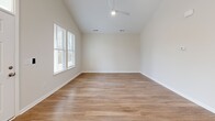 Located at 2909 Shoals Point Way in Leland, NC, this single-story, 2-bedroom, 2-bathroom home offers a thoughtfully designed layout with modern finishes throughout. The open-concept living, dining, and kitchen area serves as the heart of the home, featuring vaulted ceilings with recessed lighting and warm wood-look flooring that extends throughout. The kitchen is well-appointed with crisp white shaker cabinetry, granite countertops, a central island, and a full suite of stainless steel appliances, including a range, microwave, dishwasher, and refrigerator. Multiple windows allow natural light to fill the space. The spacious primary bedroom benefits from vaulted ceilings and a ceiling fan, creating an airy retreat, while the second bedroom provides a comfortable and versatile space. Both bathrooms feature granite-topped white vanities and wood-look flooring, with the full bath offering a tub-shower combination. A dedicated laundry room accommodates a full-size washer and dryer side by side. With five closets distributed throughout, storage is plentiful. The clean, neutral palette and consistent finishes give the home a cohesive, move-in-ready feel.