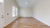 Located at 2909 Shoals Point Way in Leland, NC, this single-story, 2-bedroom, 2-bathroom home offers a thoughtfully designed layout with modern finishes throughout. The open-concept living, dining, and kitchen area serves as the heart of the home, featuring vaulted ceilings with recessed lighting and warm wood-look flooring that extends throughout. The kitchen is well-appointed with crisp white shaker cabinetry, granite countertops, a central island, and a full suite of stainless steel appliances, including a range, microwave, dishwasher, and refrigerator. Multiple windows allow natural light to fill the space. The spacious primary bedroom benefits from vaulted ceilings and a ceiling fan, creating an airy retreat, while the second bedroom provides a comfortable and versatile space. Both bathrooms feature granite-topped white vanities and wood-look flooring, with the full bath offering a tub-shower combination. A dedicated laundry room accommodates a full-size washer and dryer side by side. With five closets distributed throughout, storage is plentiful. The clean, neutral palette and consistent finishes give the home a cohesive, move-in-ready feel.