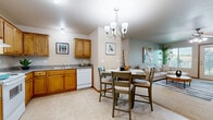 Located at 525 Stone Pointe Dr in Manhattan, Kansas, this thoughtfully designed 2-bedroom, 2-bathroom single-floor residence offers a comfortable and functional layout. The open-concept kitchen and dining area form the heart of the home, featuring warm honey-toned wood cabinetry, granite-style countertops, tile flooring, and white appliances including a refrigerator, range, and dishwasher. An elegant chandelier illuminates the dining space, which flows seamlessly into the inviting living room, where plush carpet, a ceiling fan, and natural light from windows create a relaxed atmosphere. Both bedrooms are generously sized with soft carpeting and neutral tones, offering a restful retreat. The spacious primary bedroom includes a walk-in closet with built-in shelving and a private ensuite bathroom featuring warm wood cabinetry and a large vanity mirror. A second well-sized closet serves the additional bedroom. The two bathrooms are finished with tile flooring and classic wood vanities. A dedicated laundry room with shelving and washer/dryer hookups adds everyday convenience. Two hallways connect the living spaces efficiently, completing this well-organized and comfortable home.