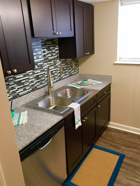 Gorgeous espresso cabinetry, granite, and mosaic tile back splash - The Arts Apartments at West Napoleon