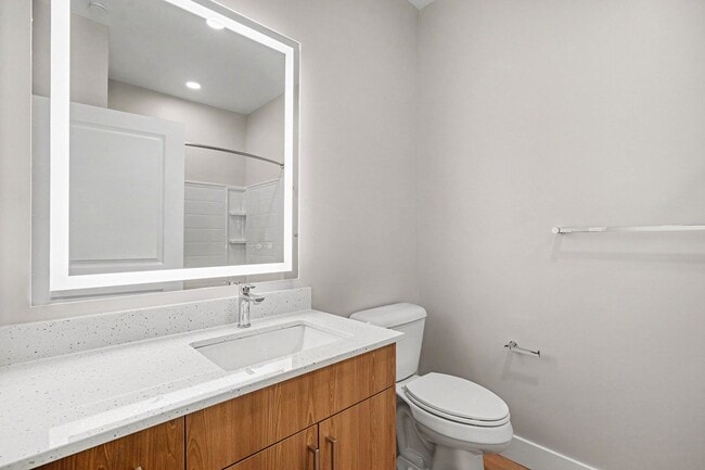 Elevate your daily routine in the modern bathroom of Trail House Apartments, featuring sleek finishes and ample storage. Enjoy a fresh, inviting space designed for convenience. Schedule a tour today to see it for yourself! - Trail House Apartments