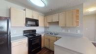 Located at 3833 Abbie Lakes Dr in Canal Winchester, Ohio, this single-floor unit offers a well-organized and practical layout designed for comfortable everyday living. The kitchen is efficiently appointed with light maple cabinetry, gray laminate countertops, dark hardwood-style flooring, and a full suite of black appliances including an electric range, over-the-range microwave, refrigerator, and a stainless steel sink. A textured ceiling and flush-mount ceiling light complete the kitchen's clean, functional aesthetic. The living area is generously sized, featuring plush neutral carpeting, a textured ceiling, and multiple windows fitted with white blinds that allow natural light to pour in. A door provides direct access to the outdoors, enhancing the sense of openness. The bedrooms are bright and carpeted, each with windows that bring in ample natural light and a neutral color palette that creates a calm, inviting atmosphere. A spacious walk-in closet with wrap-around wire shelving and hanging rods provides excellent storage capacity. The bathroom features a full tub-shower combination with built-in shelving, a toilet, and durable hardwood-style flooring, finished in a clean, neutral tone throughout. The overall ambiance of this unit is bright, clean, and move-in ready.