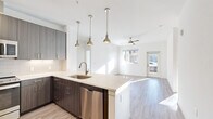 Located at 3745 Canfield St in Boulder, Colorado, this well-designed single-floor home offers three bedrooms and two bathrooms with a clean, contemporary aesthetic. The open-concept layout connects the kitchen and living room seamlessly, creating a bright and airy communal space filled with natural light. The kitchen is a standout feature, showcasing dark wood cabinetry, a light quartz peninsula with an undermount sink, stainless steel appliances including a refrigerator, range, microwave, and dishwasher, complemented by a tile backsplash and stylish pendant lighting. The living room extends the open feel with light wood-look flooring, a ceiling fan, and direct access to an outdoor area via a glass door. The bedrooms feature plush carpet flooring, ceiling fans, and natural light from exterior windows. A spacious walk-in closet with built-in shelving and hanging rods serves the primary bedroom. The bathrooms are finished with modern wood-toned vanities and large-format gray tile surrounding a soaking tub and shower. A dedicated in-unit laundry closet houses a full-size washer and dryer. A central hallway connects all rooms efficiently, rounding out this practical and polished Boulder residence.