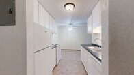 Located at 521 Westview Dr in Hastings, MN, this one-bedroom, one-bathroom residence offers a practical and well-organized single-floor layout. The galley-style kitchen features white cabinetry extending to the ceiling for ample storage, dark countertops, a double stainless steel sink, and standard appliances including a refrigerator and electric range. A ceiling fan with light fixture and tile flooring complete the kitchen's clean, functional design.

The living area is comfortably sized with neutral carpet, a ceiling fan, a wall-mounted air conditioning unit, and a baseboard heater along the exterior wall. A large window with vertical blinds allows natural light to fill the space and provides outdoor views of the surrounding greenery.

The bedroom is a generously proportioned room with soft carpet, its own baseboard heater, a window with vertical blinds for natural light, and a textured ceiling. A ceiling fan provides additional climate comfort in this restful retreat.

The full bathroom includes a white tiled tub and shower combination, accented with chrome accessories such as grab bars, shelving caddies, and towel bars, presenting a clean and well-maintained space.

A connecting hallway ties the layout together, offering efficient flow between all areas of the home. Baseboard heating is consistent throughout, ensuring year-round comfort in this straightforward and livable Hastings residence.