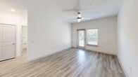 Located at 6000 Front St in Summerville, SC, this single-story, 3-bedroom, 2-bathroom home offers a bright and modern interior designed with a clean, neutral palette. Light wood-look flooring flows consistently throughout every room, creating a cohesive and airy feel. The open layout connects living areas seamlessly, with a hallway leading to the kitchen, which features dark cabinetry and light granite countertops visible from the main corridor.

Each bedroom is well-proportioned, finished with white walls, ceiling fans, and natural light from blinded windows. The generously sized primary bedroom stands out as a true retreat, offering ample space and direct access to a walk-in closet outfitted with wrap-around shelving and hanging rods. The primary bathroom includes a glass-enclosed walk-in shower, a granite-topped vanity with dark cabinetry, and brushed nickel grab bars and fixtures. The second bathroom mirrors this refined style with its own granite vanity and coordinating finishes.

A dedicated utility room and additional closet provide practical storage solutions. The living area features a ceiling fan and a glass door with a sidelight window that invites natural light and outdoor views. The overall ambiance is clean, contemporary, and move-in ready.
