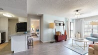 Located at 15420 Livingston Ave in Lutz, Florida, this single-floor residence offers a well-designed layout with a seamless flow between living spaces. The open-concept living room is bright and inviting, featuring wood-look flooring, large windows with natural light, and sliding glass door access to an outdoor balcony with greenery views. Soft, neutral tones on the walls are complemented by textured ceilings throughout.

The galley-style kitchen is well-appointed with white shaker cabinetry, granite countertops, a subway tile backsplash, black appliances including a range, microwave, dishwasher, and refrigerator, plus a breakfast bar for casual dining.

The two bedrooms are comfortably sized, each featuring plush carpeting, generous windows with outdoor views, and ceiling fans or overhead lighting. The primary bedroom includes a window seat area, offering a cozy retreat with natural light.

Both bathrooms are finished with granite-top vanities, white cabinetry, and wood-look flooring. One bathroom features a tub-shower combination, while the second includes a walk-in shower setup, each with clean, neutral finishes that contribute to the overall polished aesthetic of the home.