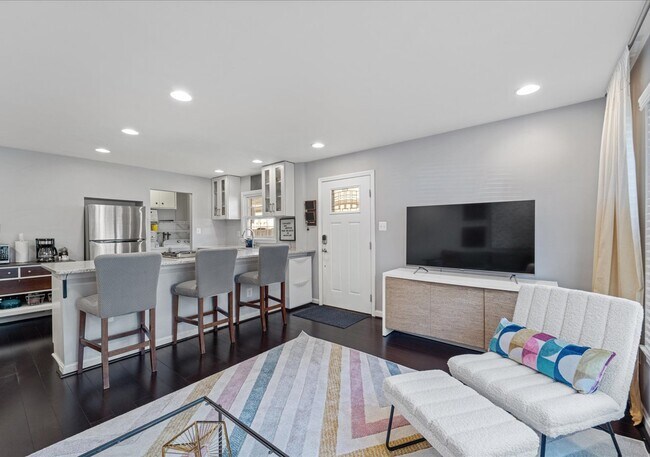 Sala de estar y cocina de concepto abierto con pisos de madera real y electrodomésticos renovados. - 706A W Glebe Rd