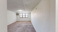 Located at 4410 Township Line Road in Drexel Hill, PA, this one-bedroom, one-bathroom unit offers a practical and well-organized single-floor layout. The living room is a generously sized, light-filled space featuring neutral carpeting, white walls, and baseboard heating. Windows allow natural light to filter in, creating a bright and open atmosphere. The spacious primary bedroom continues the same carpeted flooring and neutral palette, with multiple windows fitted with blinds and a window air conditioning unit, ensuring year-round comfort. Two closets provide ample storage throughout the unit. The kitchen is efficiently designed with warm honey-toned wood cabinetry, dark granite-style countertops, and a dark mosaic tile backsplash. It is equipped with a gas range, stainless steel dishwasher, refrigerator, and a stainless steel sink, all set on light ceramic tile flooring. The bathroom features a retro aesthetic with bold amber and teal wall tiles, mosaic tile flooring, a soaking tub, pedestal-style sink, and a window that brings in natural light. A connecting hallway ties all rooms together for a cohesive and functional flow throughout this cozy Drexel Hill residence.