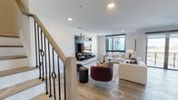 Fifty58 PH8 is a well-appointed two-floor penthouse that blends contemporary design with functional elegance. The main living area anchors the lower floor, featuring light wood flooring, recessed lighting, and a sleek wall-mounted media unit. A staircase with a light wood railing and distinctive black iron balusters connects the two levels, adding architectural character to the space. The open-concept kitchen is a standout feature, equipped with a waterfall-edge island with bar seating, two-toned cabinetry in white gloss and dark wood, stainless steel appliances, and geometric pendant lighting. The adjacent dining area enjoys direct access to a private balcony through floor-to-ceiling sliding glass doors, offering open exterior views. The upper floor hosts the bedrooms, including a primary suite with large sliding glass doors leading to its own private balcony, an upholstered accent wall, and ample natural light. Additional bedrooms offer clean lines, light wood flooring, and generous window placement. A full bathroom features neutral tile work, a soaking tub, and dark wood vanity cabinetry with a white countertop. A versatile flex room with built-in shelving and Murphy-style cabinetry provides adaptable living space. Throughout, the penthouse maintains a cohesive, modern aesthetic with light tones and refined finishes.