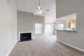 Located in Sterling, VA, this two-story home offers 3 bedrooms, 5 bathrooms, and a thoughtfully designed layout spread across two floors. The main floor commands attention with a dramatic vaulted ceiling in the living room, accentuated by a ceiling fan and abundant natural light streaming through multiple windows. A classic fireplace with a dark surround serves as the focal point of the living area, which flows seamlessly into the dining space. The kitchen features light wood cabinetry, dark granite-style countertops, black appliances, and tile flooring, connected to the living area via a convenient breakfast bar peninsula. The main floor also hosts the spacious primary bedroom, which boasts a charming bay window with a built-in seat, offering peaceful outdoor views and ample natural light. Bathrooms are well-appointed with light wood vanities, white countertops, and a glass-door walk-in shower. Bedrooms are carpeted in neutral tones, providing a warm and comfortable feel. The upper floor provides additional living space with its own rooms and closets. Throughout, the home maintains a neutral gray-and-white palette, creating a clean, move-in-ready aesthetic complemented by generous closet storage across all levels.